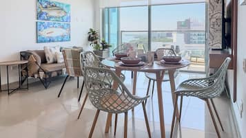 A modern dining area with a view of the cityscape through large windows.