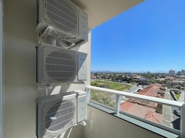 Varanda com três unidades de ar condicionado identificadas como 'elgin' e 'Inverter'.