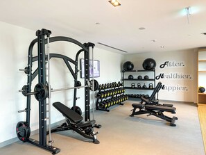 A gym with weightlifting equipment, dumbbells, and a wall with motivational text. - Luxury 1BR Downtown Views Walk to Burj Khalifa (Dubai)