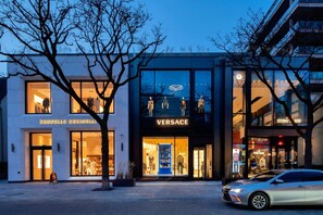 Un bâtiment moderne abritant des boutiques de Brunello Gucci et de Versace.