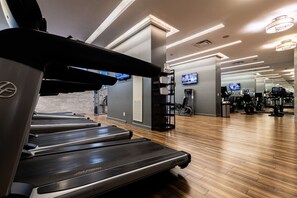 A gym with treadmills, exercise equipment, and a modern design. - Chic 1 BR Yorkville  Suite (Toronto)