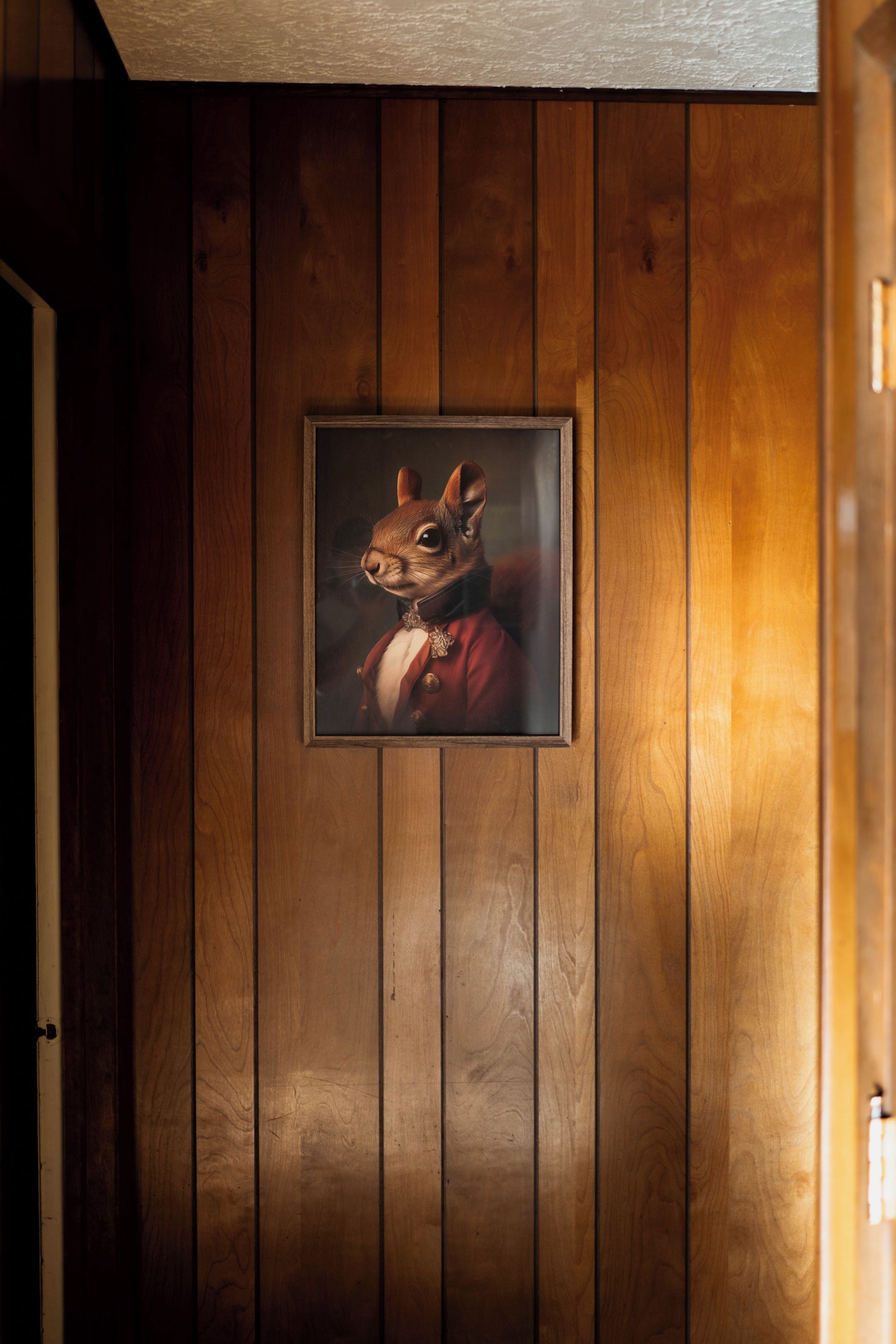 A framed picture of a squirrel in a suit on a wooden wall.