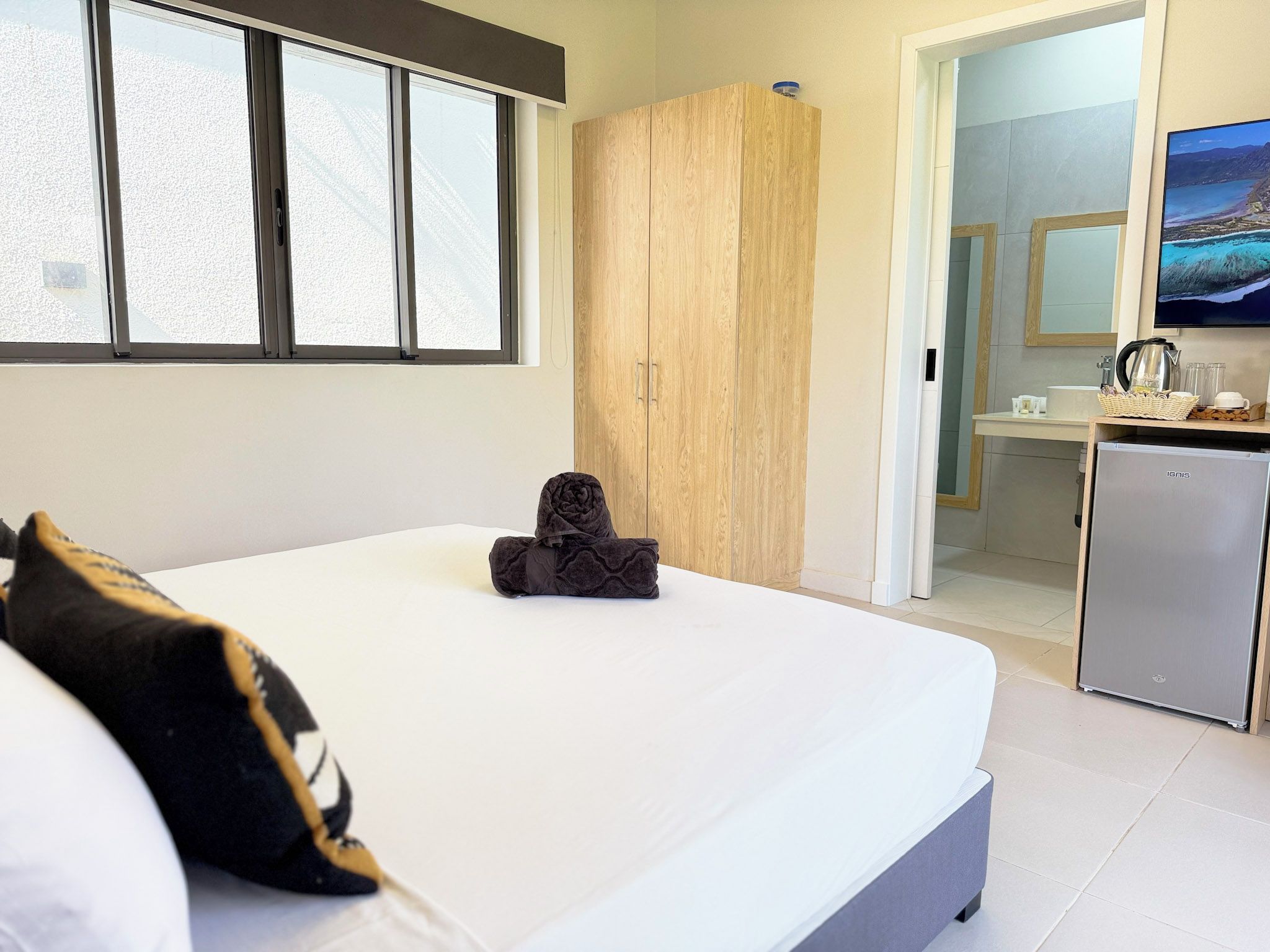 Un dormitorio con cama, armario, kitchenette y baño.