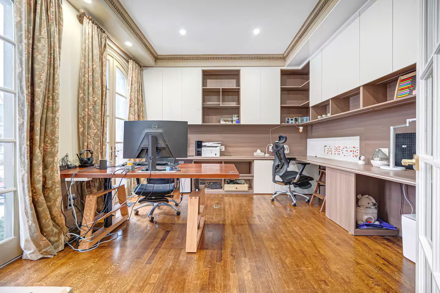 A modern office space with a wooden desk, computer, and office chair.