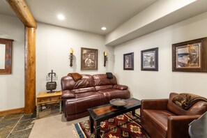 A living room with a brown leather sofa, a wooden coffee table, and a patterned rug. - Mountain Village Gem|Hot Tub+Views+Ski-In/Out (Mountain Village)