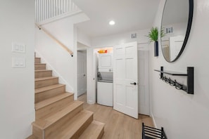 A staircase leading to a room with a white door, a mirror, and a shelf with glasses. - 2 Lux twin townhomes/King bds/Pool tables/Groups (Phoenix)
