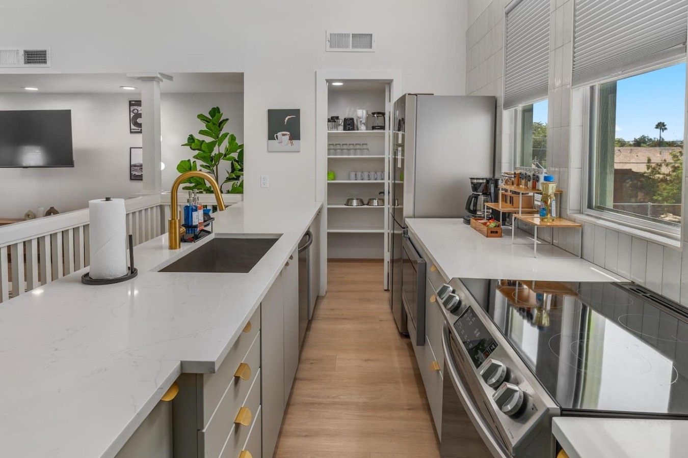 Een moderne keuken met een centraal eiland, inbouwapparatuur en uitzicht door het raam.
