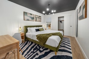 A bedroom with a bed, bedside table, lamp, and a zebra-patterned rug. - 2 Lux twin townhomes/King bds/Pool tables/Groups (Phoenix)