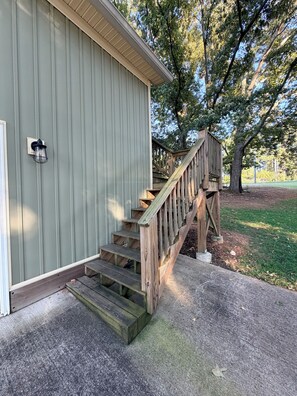 A building with a wooden staircase leading to a deck.