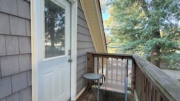 A wooden deck with a door and a small table.