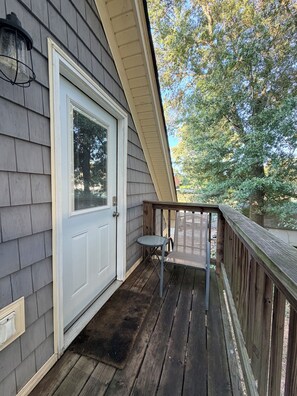 A wooden deck with a door and a small table.