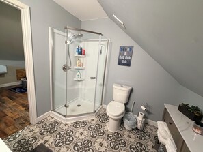 Une salle de bain avec une douche à parois de verre, des toilettes et un lavabo doté d’un plan de travail en marbre.