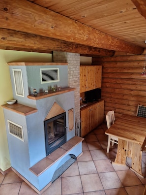 Una cocina rústica con chimenea empotrada, armarios de madera y una mesa de comedor.