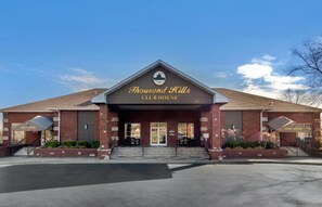 A brick building with a sign reading 'Thousand Hills Clubhouse' and a golf shop to the left. - Central Branson Suite • 2 Queen Beds • Sleeps 4 (Branson)