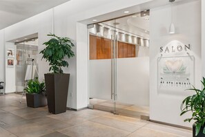 Een modern interieur met een salon, een receptiehoek en een plant.