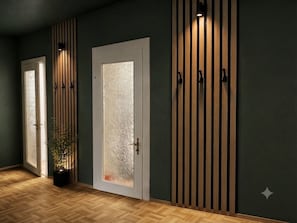 A hallway with wooden flooring, frosted glass doors, and vertical wooden slats on the walls.