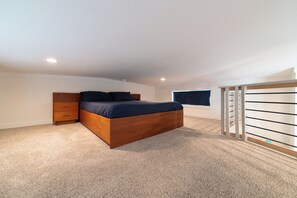 A bedroom with a wooden bed, a nightstand, a window, and a built-in closet with a sliding door. - The Wanderlust Nest Tiny Home with Resort Access (Austin)