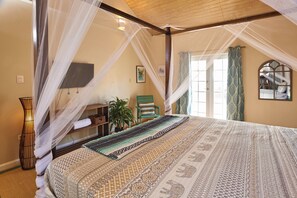 A bedroom with a canopy bed, a potted plant, a wooden chair, and a mirror on the wall. - Surfers Paradise Villa, front row seats to the most breathtaking beach sunsets. (Mt. Irvine)