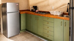A kitchen with green cabinets, a stainless steel refrigerator, a wooden countertop, and two pendant lights. - House in Jalatlaco, pet-friendly and with a garage. (Oaxaca de Juárez)