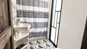 A bathroom with a toilet, a sink, a shower curtain with a zebra pattern, and a window. - House in Jalatlaco, pet-friendly and with a garage. (Oaxaca de Juárez)