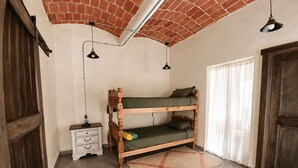 A bunk bed with a wooden frame, a small bedside table, a lamp, and a window with curtains. - House in Jalatlaco, pet-friendly and with a garage. (Oaxaca de Juárez)