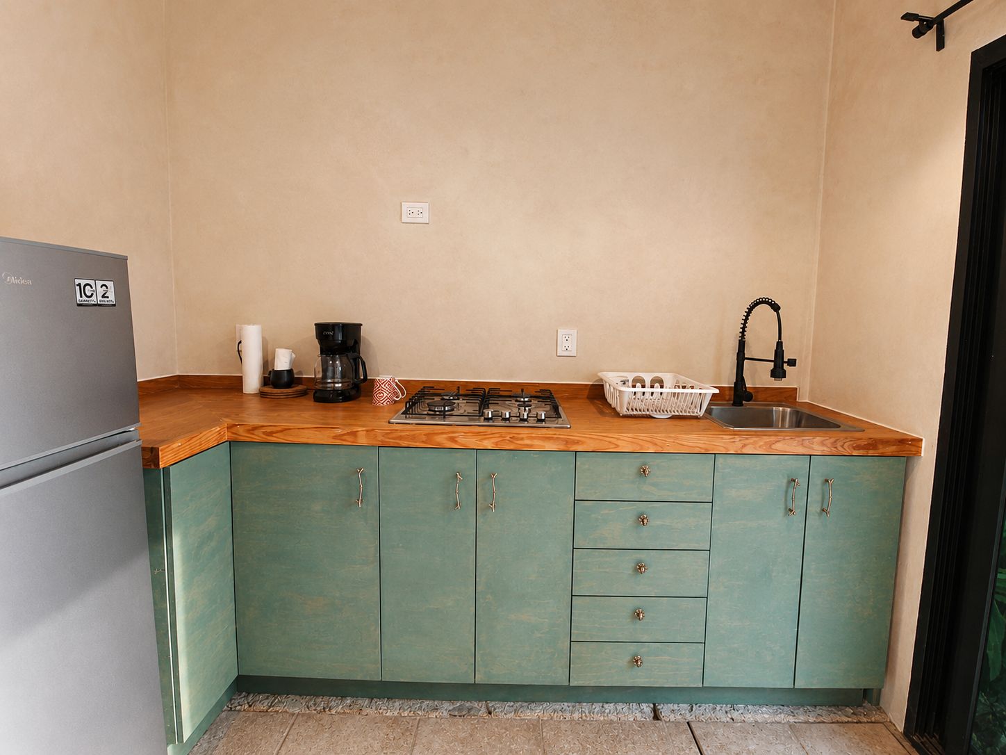 A compact kitchen with a built-in refrigerator, a gas stove, and a sink.
