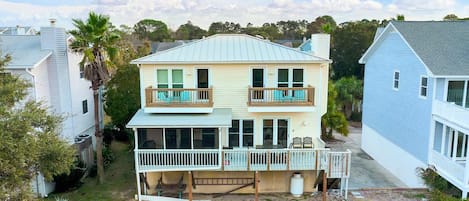 A two-story house with a balcony on the second floor and a covered porch on the ground floor.