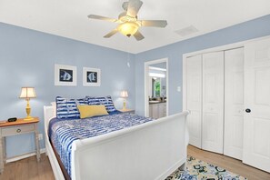 A bedroom with a bed, two bedside tables with lamps, a ceiling fan, and a wardrobe. - Beachfront Villa on Tybee Island - Sleeps 8, Steps to the Sand (Tybee Island)