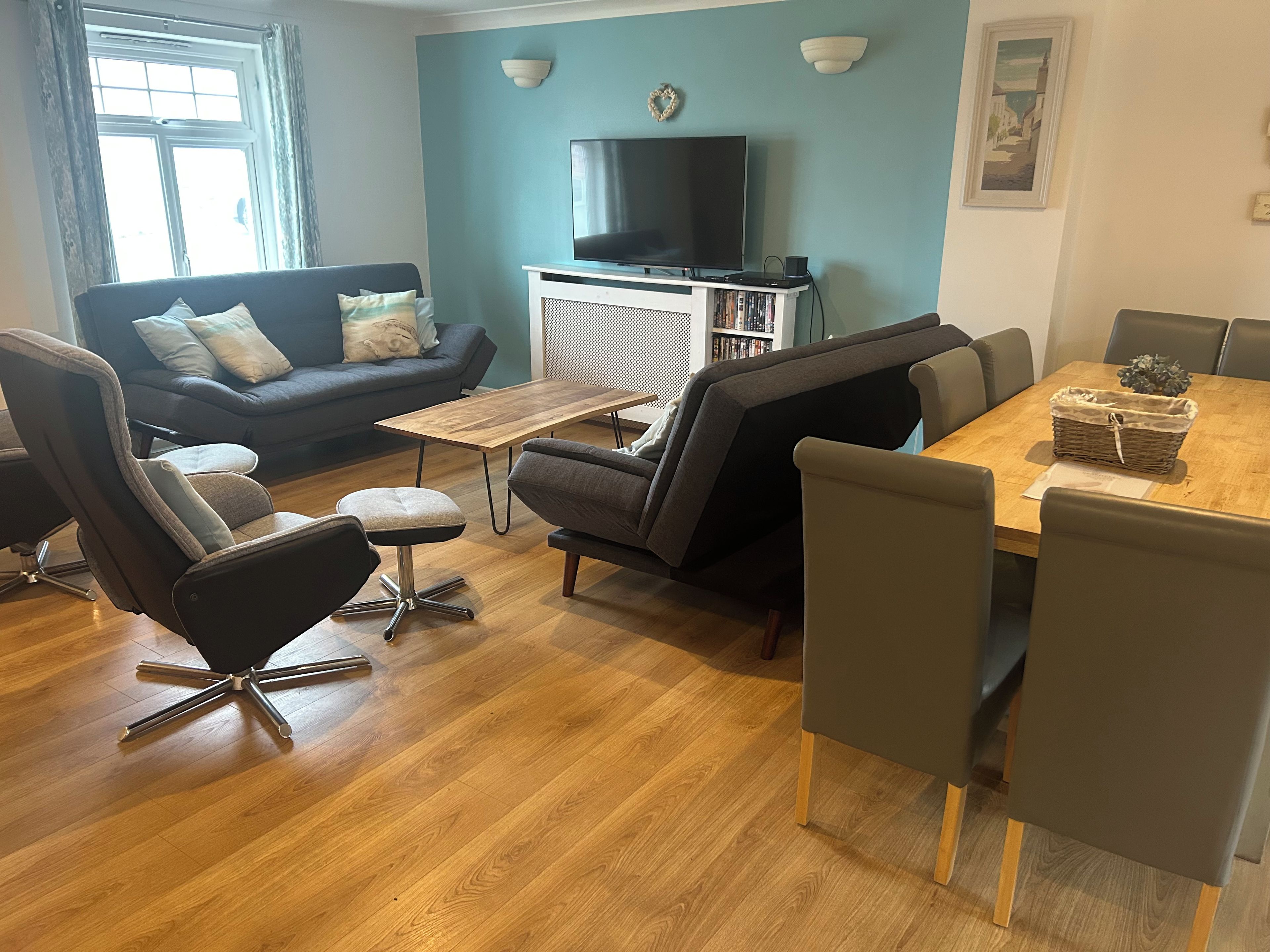 Uma sala de estar moderna com sofá, mesa de centro e aparador com televisão de tela plana e estante.