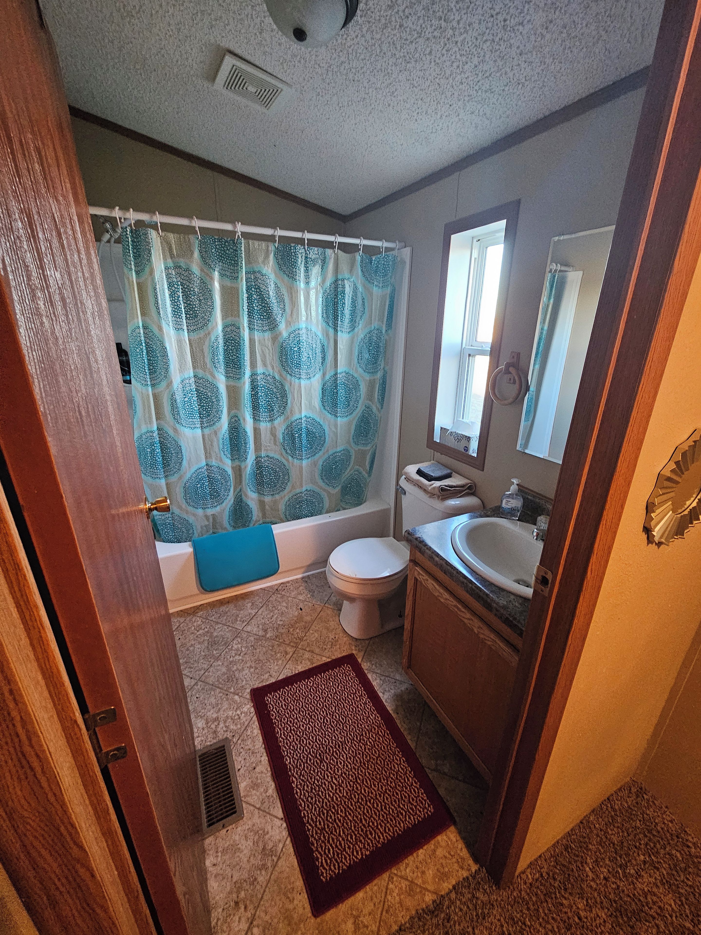 Ein Badezimmer mit Badewanne, Toilette, Waschbecken und Duschvorhang.