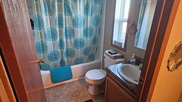Ein Badezimmer mit Badewanne, Toilette, Waschbecken und Duschvorhang.