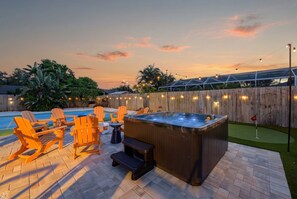 A backyard with a hot tub, outdoor seating, a pool, and a wooden fence. - Sports Court • Putt Putt • Gym • Pool • Hot Tub (Bradenton)