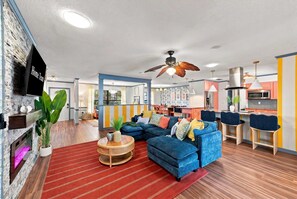 A modern living room with a blue sofa, a wooden coffee table, and a red striped rug. - Sports Court • Putt Putt • Gym • Pool • Hot Tub (Bradenton)