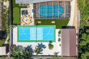 An aerial view of a residential property with a swimming pool, a tennis court, and a hot tub area. - Sports Court • Putt Putt • Gym • Pool • Hot Tub (Bradenton)