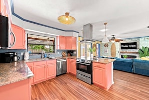A modern kitchen with pink cabinets, stainless steel appliances, and a central island. - Sports Court • Putt Putt • Gym • Pool • Hot Tub (Bradenton)