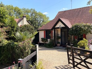 Ein ländliches Anwesen mit einer Schotterauffahrt, die zu einem Haus mit roten Ziegeln führt.