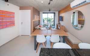 Un interior moderno con una zona de comedor, un espejo grande y vistas al exterior.