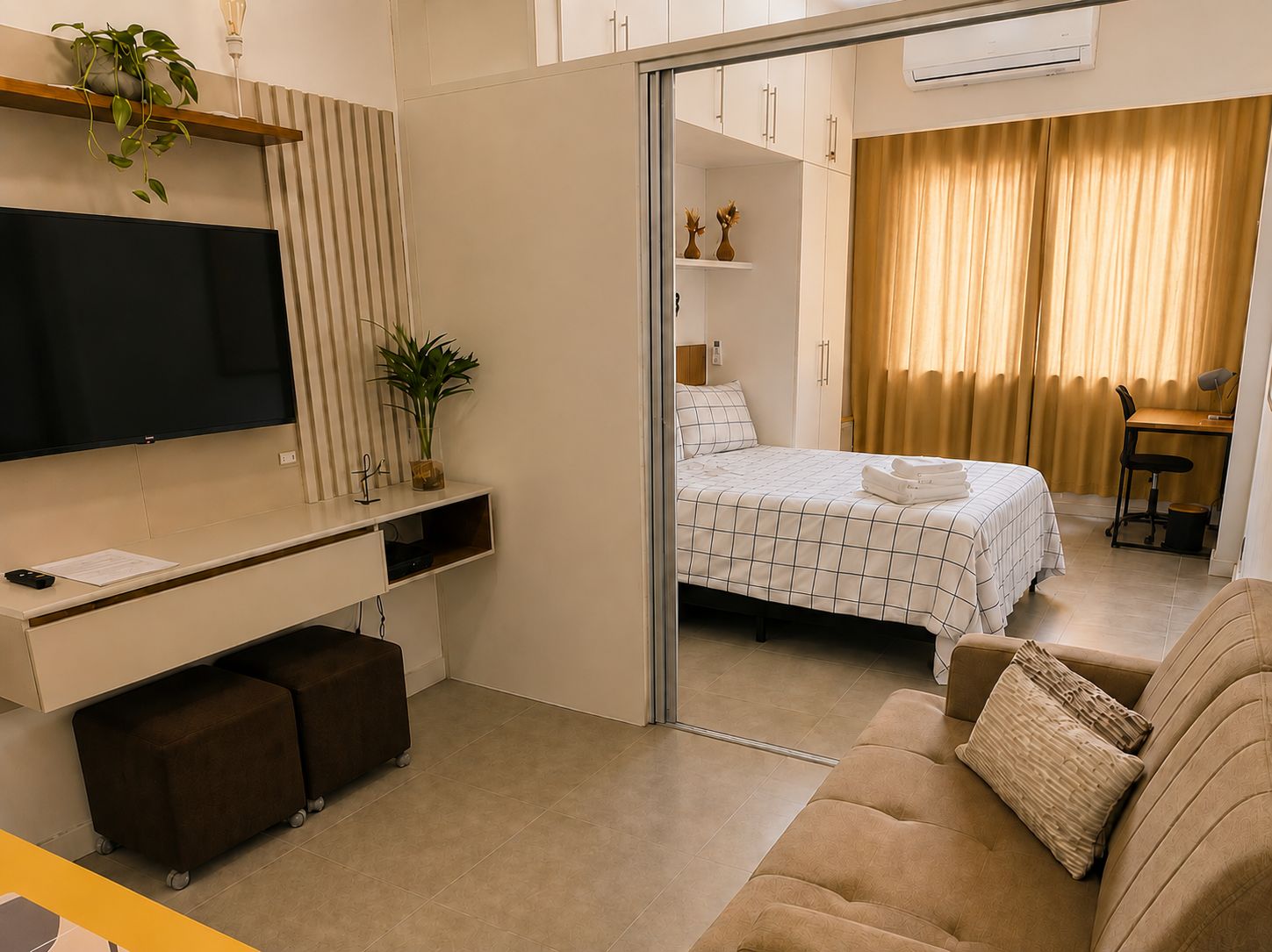 Une chambre d’hôtel avec un lit, une télévision, un bureau et un canapé.