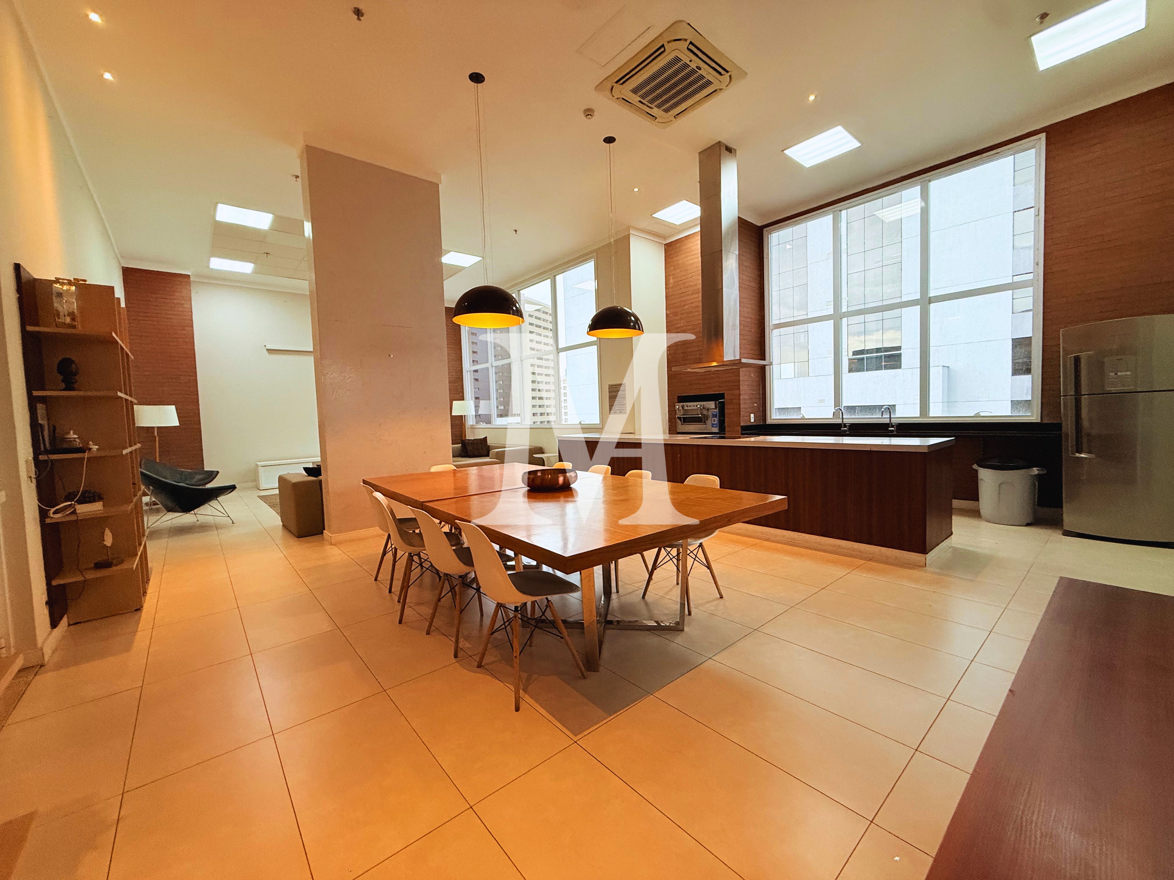 Una cocina moderna con comedor, ventanas amplias y horno empotrado.