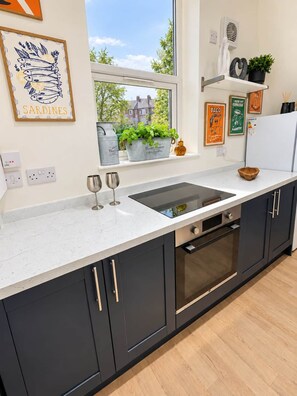 A modern kitchen with a large window, a sink, and a built-in oven. - King Bed • Free Parking • Stylish 1BR (Liverpool)