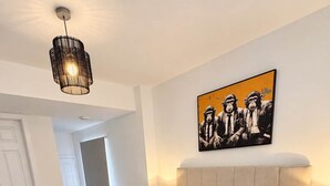 Una camera da letto con un letto grande, una lampada a sospensione e un'opera d'arte appesa al muro.