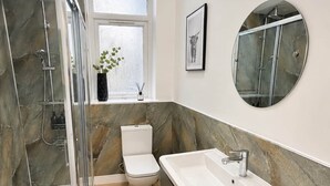 Un bagno moderno con cabina doccia, toilette e mobile lavabo.