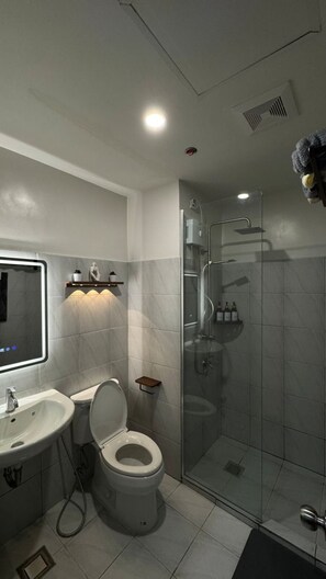 Ein modernes Badezimmer mit Toilette, Waschbecken und Dusche.