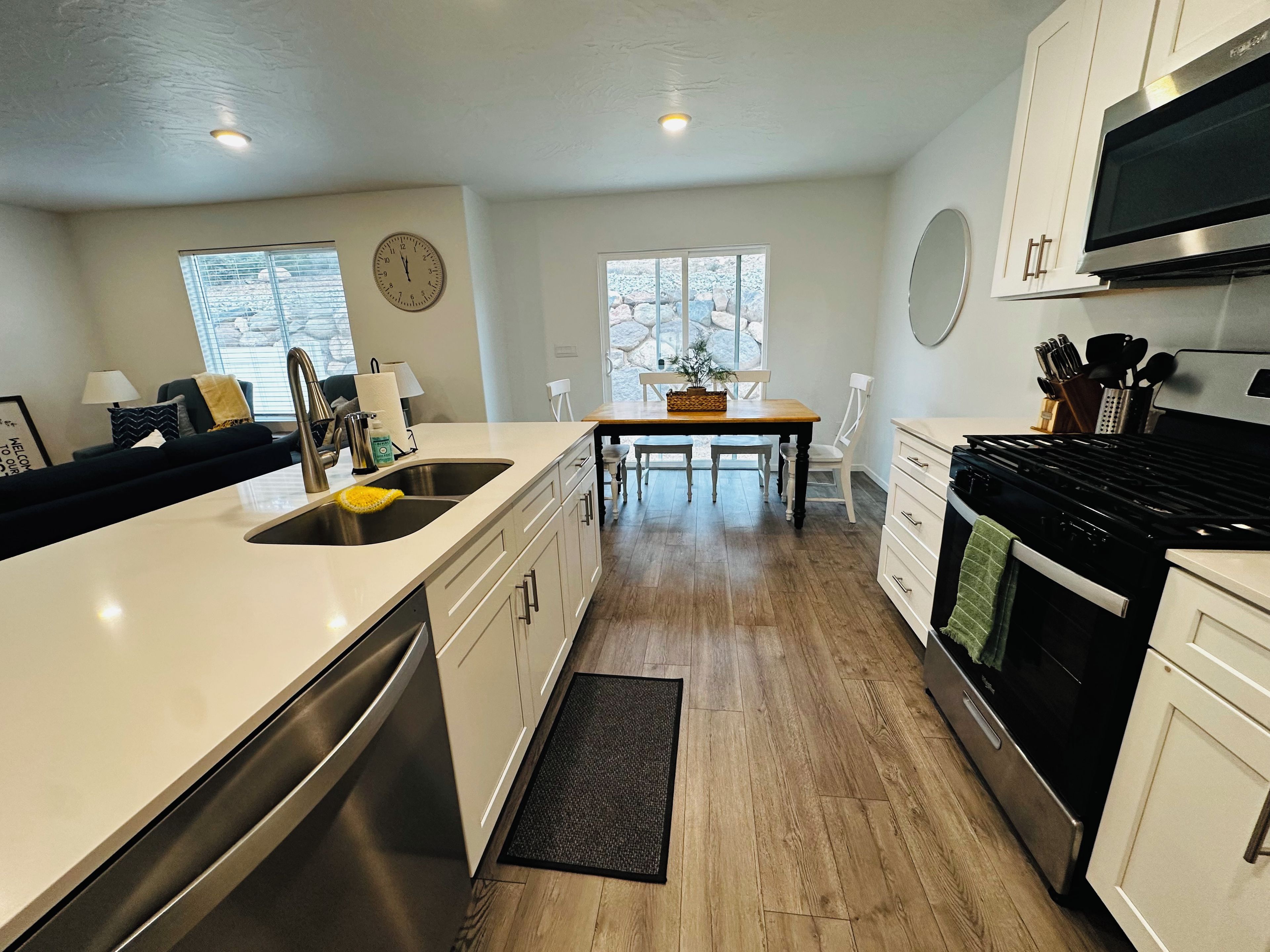 A modern kitchen with a central island, stainless steel appliances, and a dining area with natural light.
