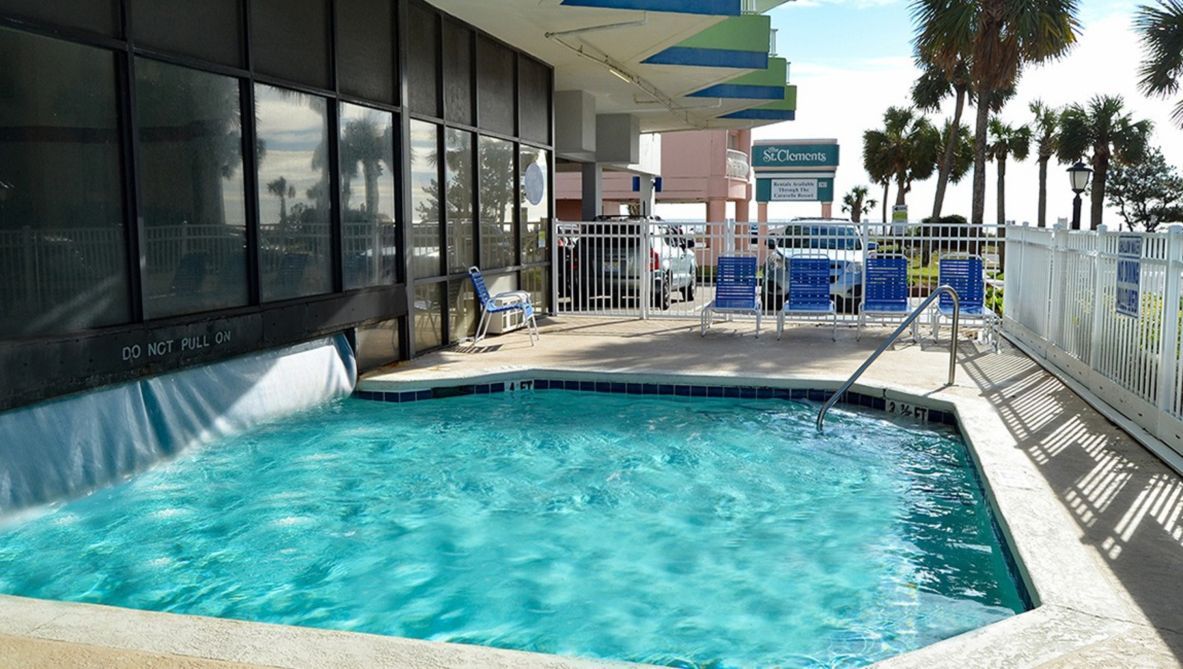 A swimming pool with a 'DO NOT PULL ON' sign, lounge chairs, and a fenced area with a sign for 'SCCenters'.