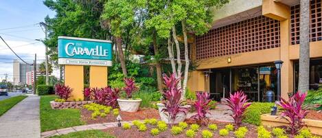 Une enseigne d’hôtel indiquant « The Caravelle », avec un jardin devant.