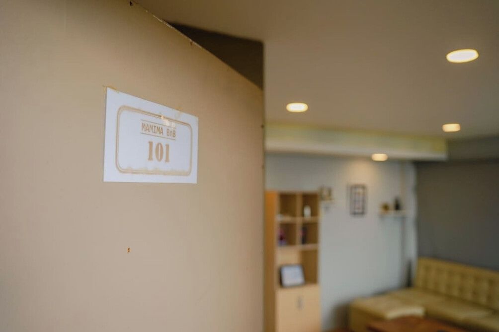 Un couloir avec une pancarte indiquant le numéro de la pièce : 101.