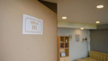 Un couloir avec une pancarte indiquant le numéro de la pièce : 101.