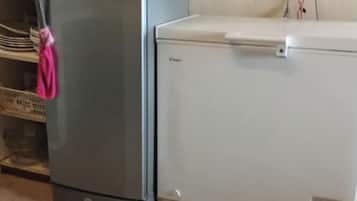 Uma cozinha com geladeira e máquina de lavar branca.