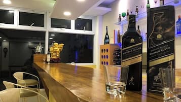Een bar met een houten toonbank, twee flessen Johnnie Walker Double Black, en een gouden beeldje.